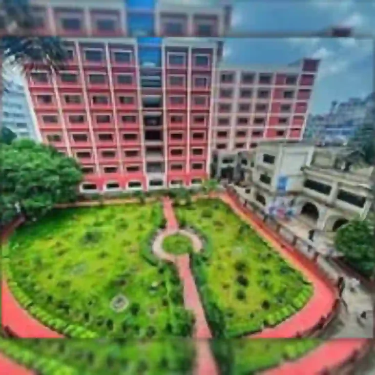 Red building with a green courtyard and pathways, image partially blurred.