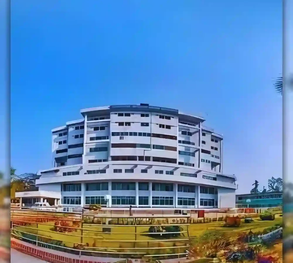 Modern multi-story building with a curved design under a clear blue sky.