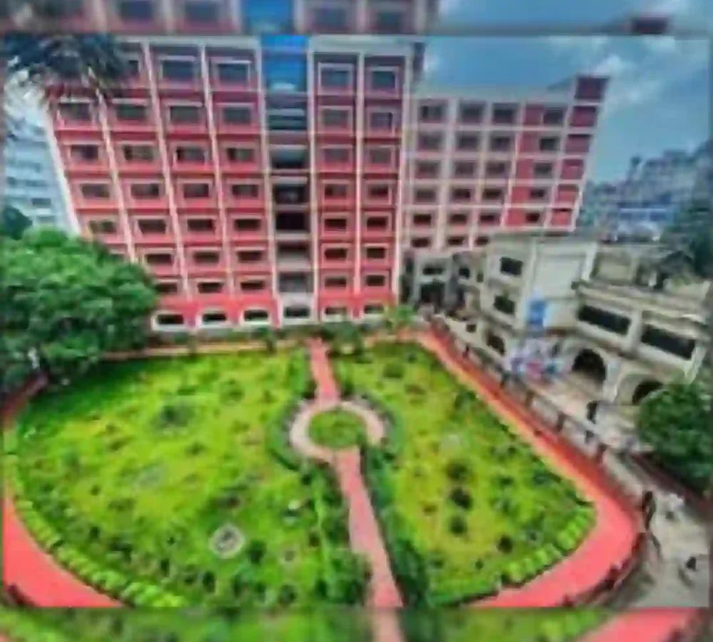 Red building with a green courtyard and pathways, image partially blurred.